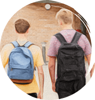 Two boys wearing backpacks walking to school entrance